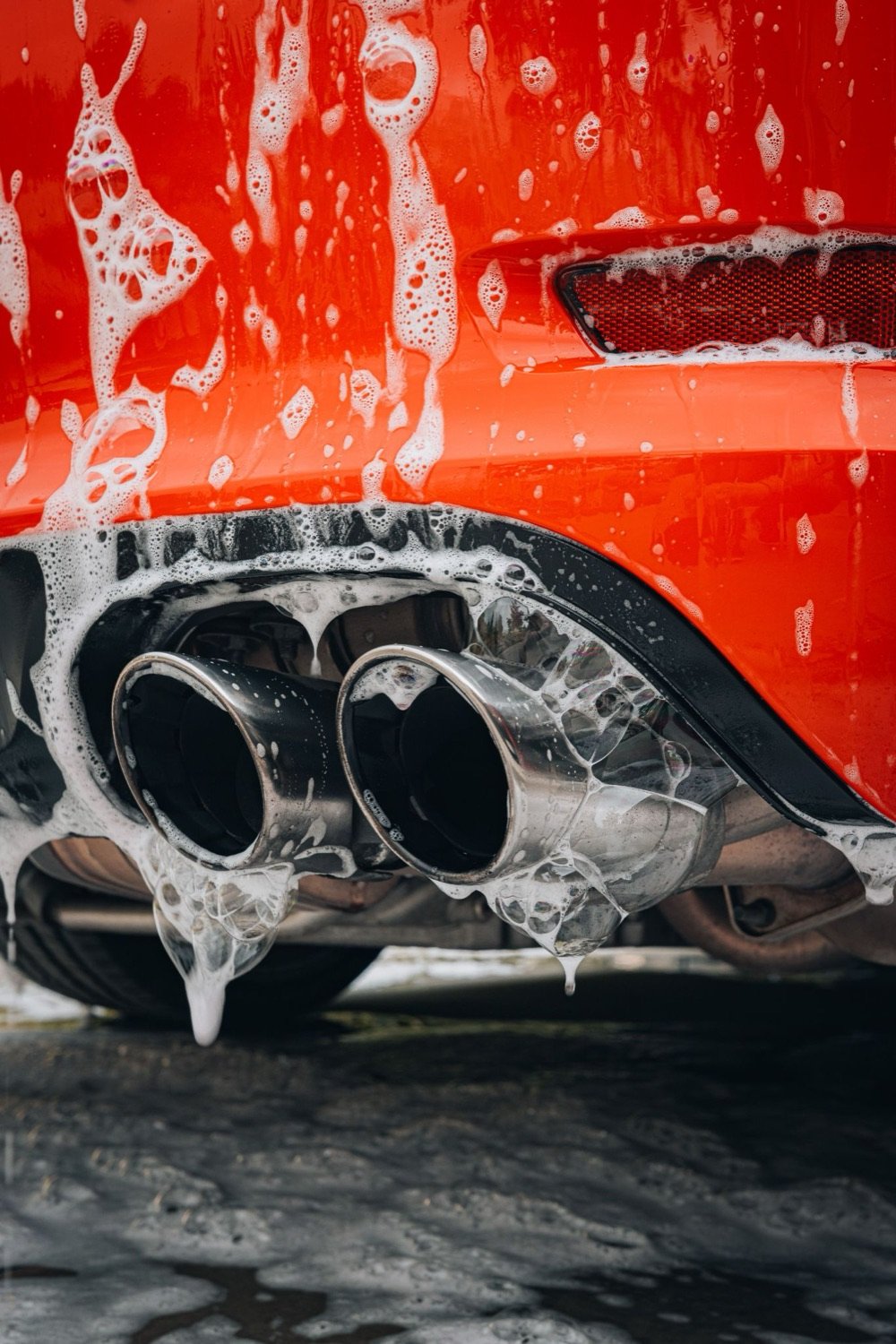 Foam around the exhaust tips of a red car