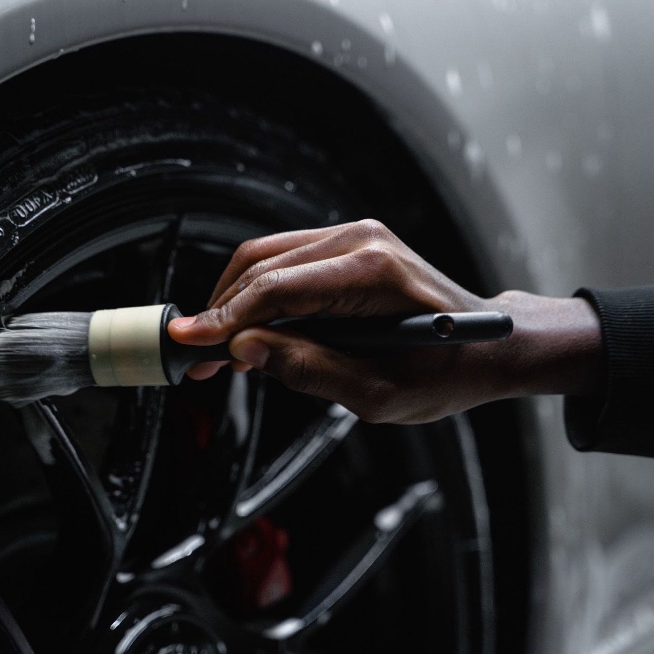 Detailing brush cleaning a wheel